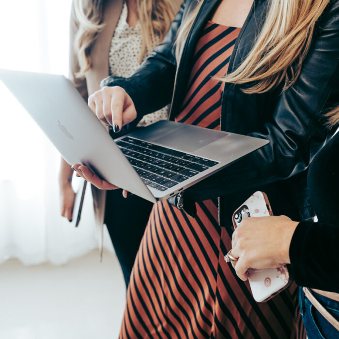 Two Mina Company team members holding laptops