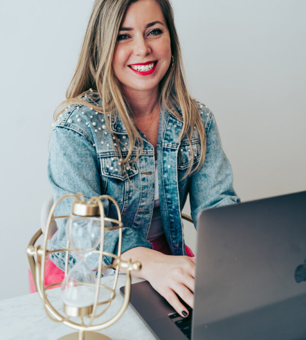 Mina Company team member smiling while working on a laptop
